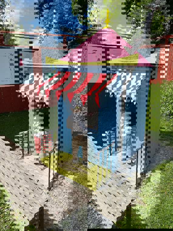 Barn leker vid en blå kiosk